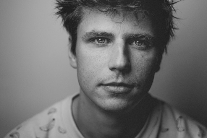 Black and white portrait photography of a man using a light meter for perfect tone.