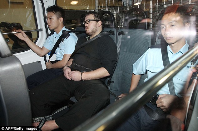 Court date: A handcuffed Rurik Jutting is taken to a Hong Kong court by police car after being charged with the murders of the two women 